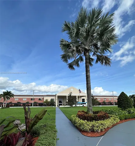 a front view of a house with a yard and potted plants