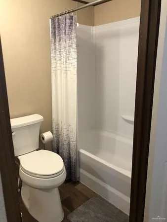 a white toilet sitting next to a bath tub