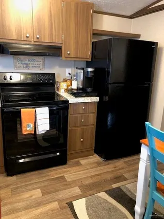 a kitchen with stainless steel appliances kitchen island granite countertop a refrigerator stove and microwave