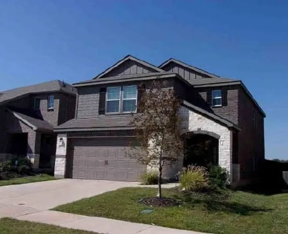 a front view of a house with a yard and garage