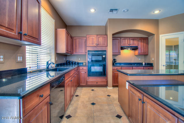42811 West Venture Road Maricopa, AZ 85138 - Photo 28 of 61 a kitchen with stainless steel appliances granite countertop a sink and stove