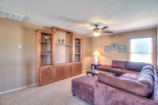 42811 West Venture Road Maricopa, AZ 85138 - Photo 5 of 61 a living room with furniture a ceiling fan and a window