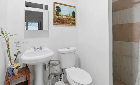 a bathroom with a toilet sink and mirror