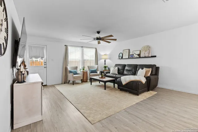 a living room with furniture a window and a flat screen tv