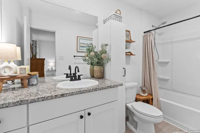 a bathroom with a shower a toilet and a sink