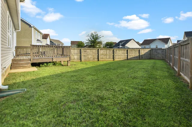 a view of yard with green space and bench