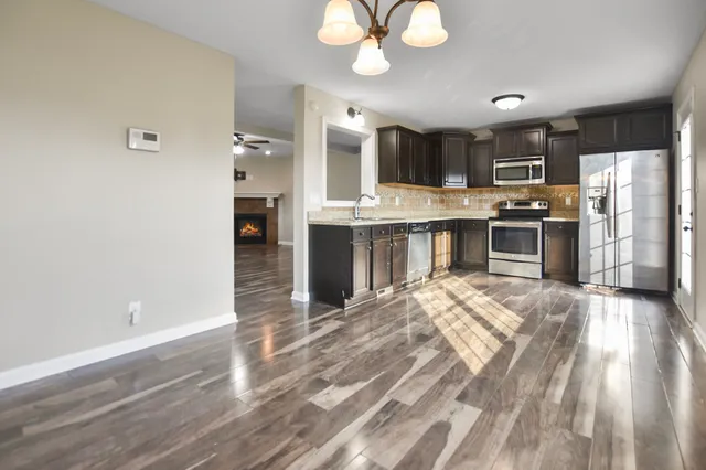 a large kitchen with cabinets wooden floor and stainless steel appliances