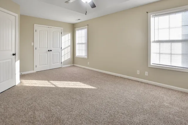 an empty room with windows and closet