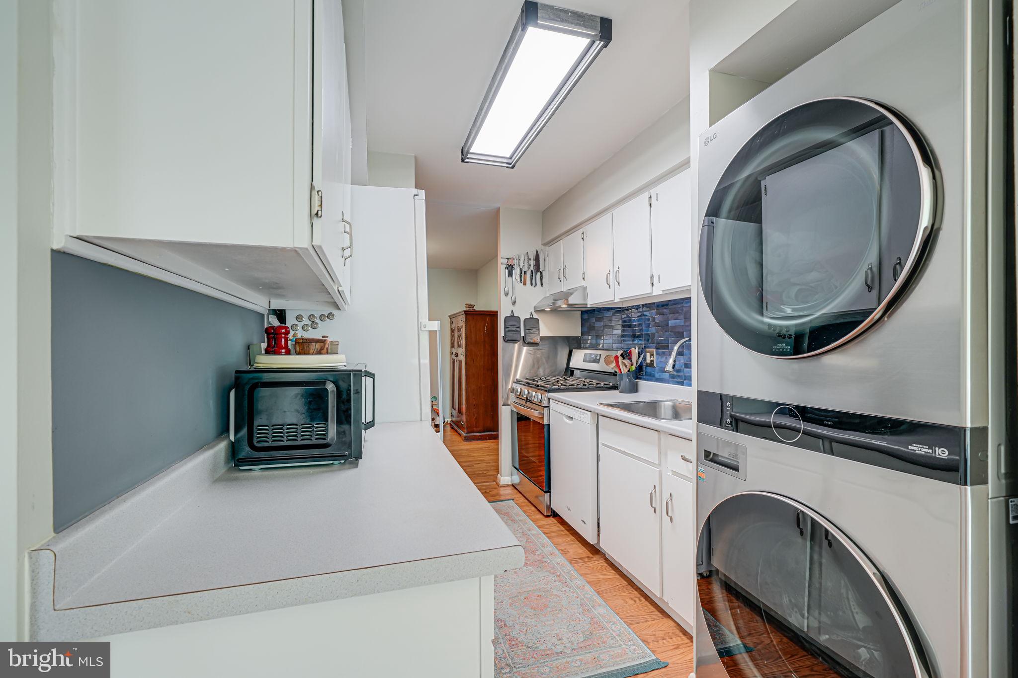 11220 Chestnut Grove Square, Unit 222 Reston, VA 20190 - Photo 11 of 35 a kitchen with kitchen island a stove a sink and a refrigerator