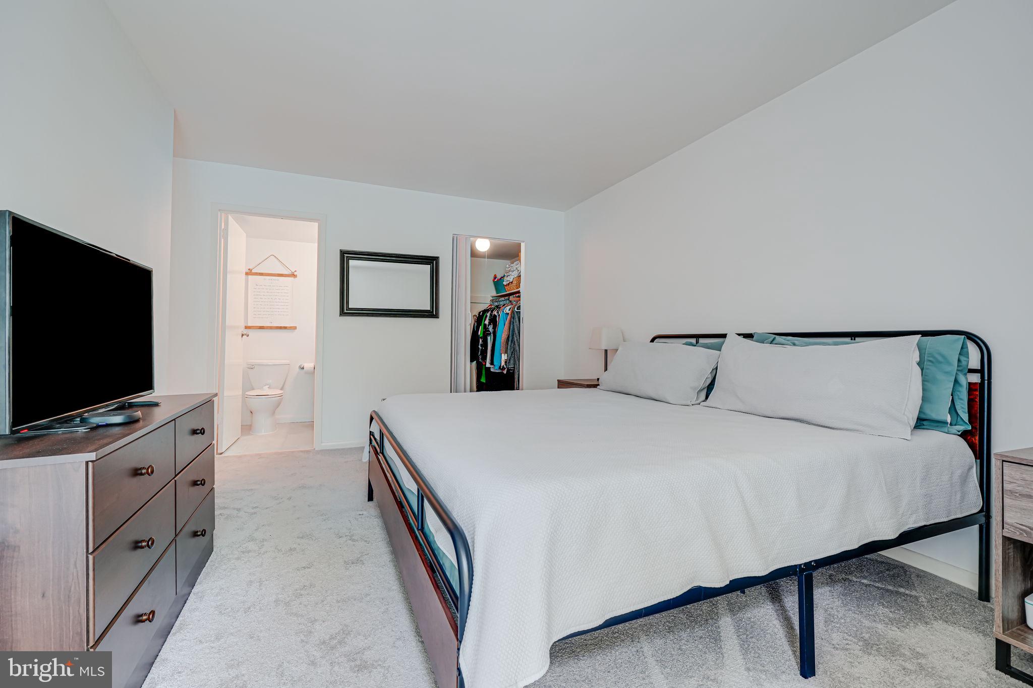11220 Chestnut Grove Square, Unit 222 Reston, VA 20190 - Photo 26 of 35 a bedroom with bed and flat screen tv
