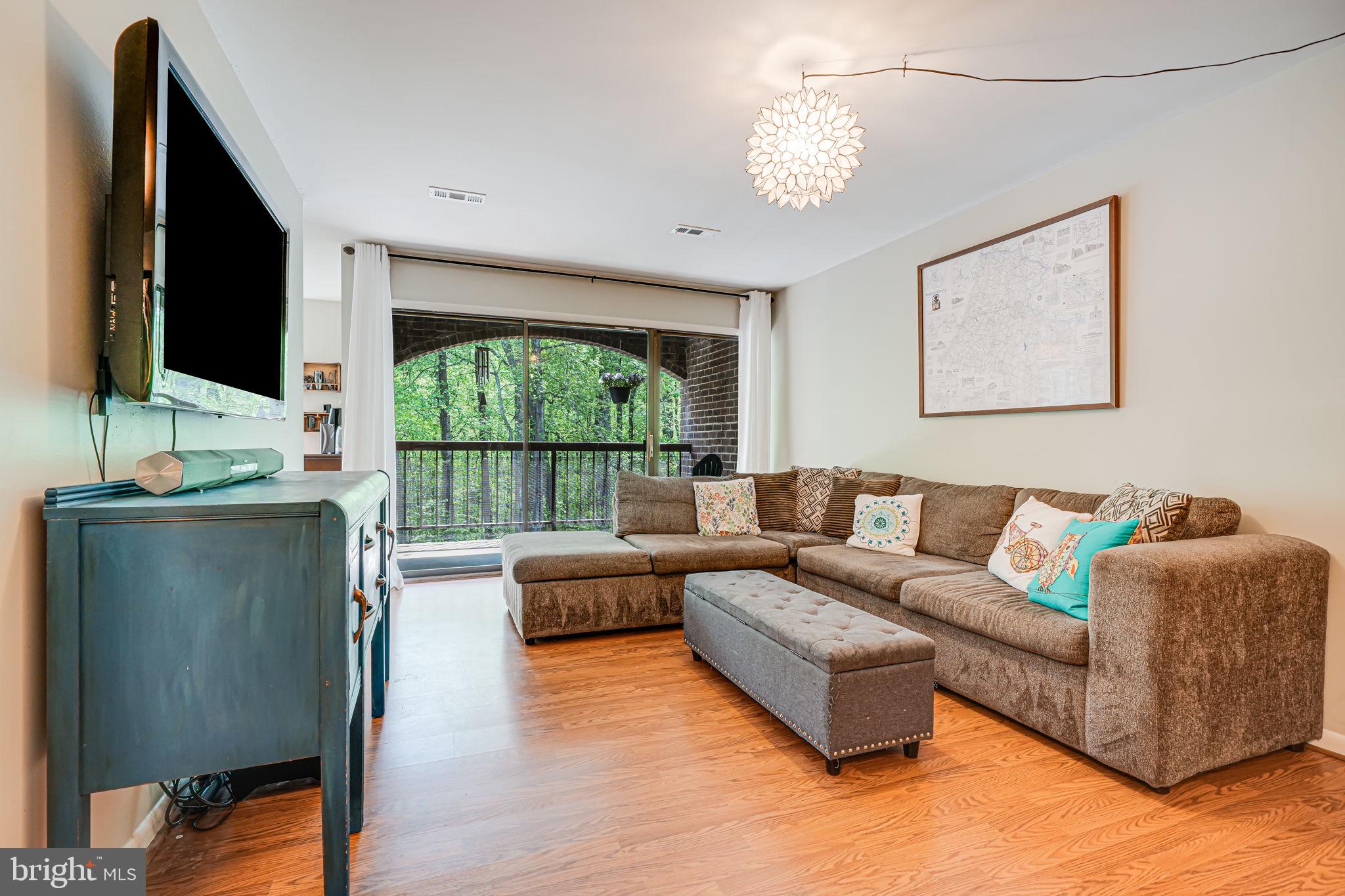 11220 Chestnut Grove Square, Unit 222 Reston, VA 20190 - Photo 5 of 35 a living room with furniture flat screen tv and a large window
