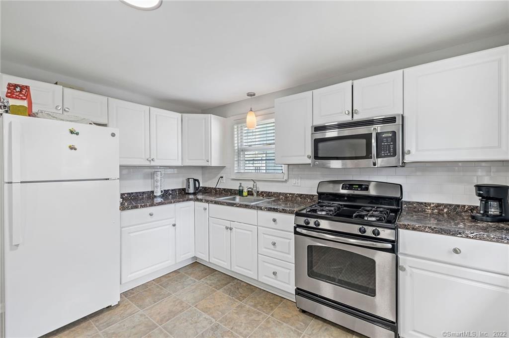 24 Ricky Lane, Unit 24 Norwalk, CT 06854 - Photo 1 of 1 a kitchen with granite countertop white cabinets sink and stainless steel appliances