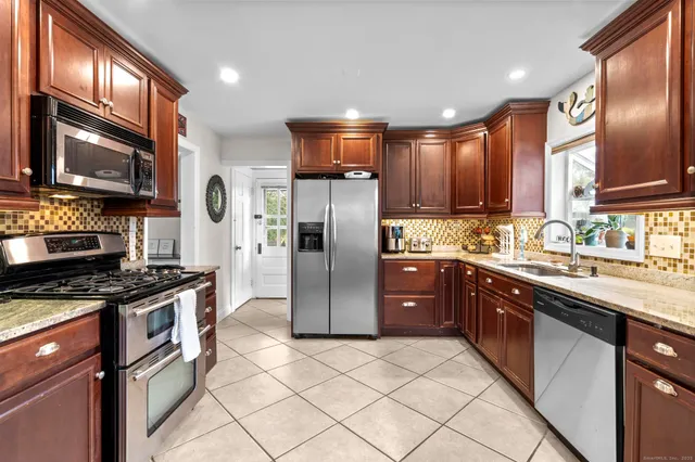 a kitchen with stainless steel appliances granite countertop a stove and a sink