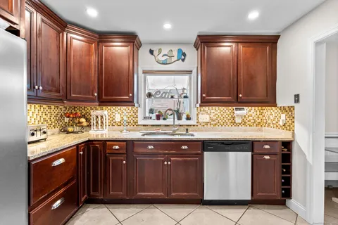 a kitchen with stainless steel appliances granite countertop a refrigerator and a sink
