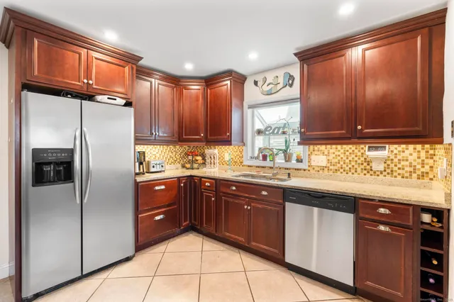 a kitchen with a refrigerator and a stove top oven