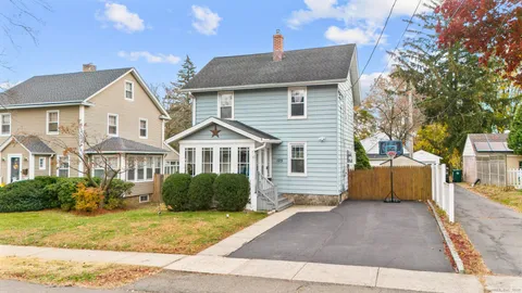 a front view of a house with a yard and trees