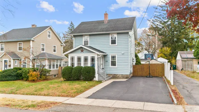 a front view of a house with a yard and trees