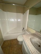 910 Duncan Lane, Unit 61 Austin, TX 78705 - Photo 18 of 22 a bathroom with a granite countertop sink a toilet and shower