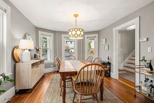 a dining room with furniture a chandelier and wooden floor