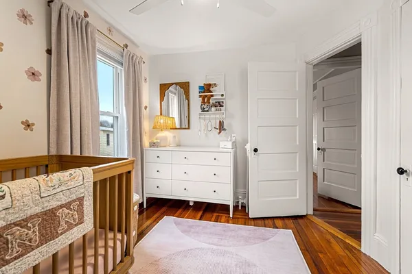 a bedroom with a dresser and a window