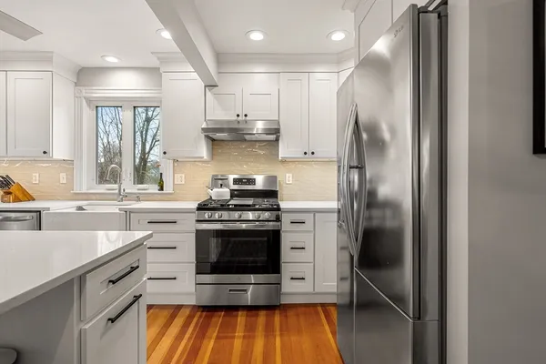 a kitchen with stainless steel appliances granite countertop a stove a refrigerator and a sink