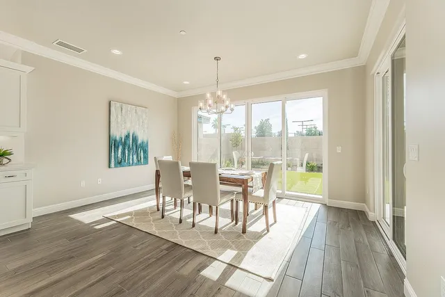 an empty room with wooden floor chandelier fan and windows