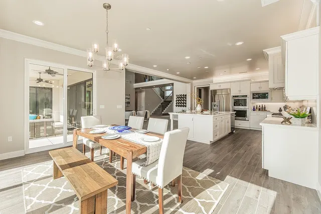 a view of an empty room with wooden floor and a ceiling fan