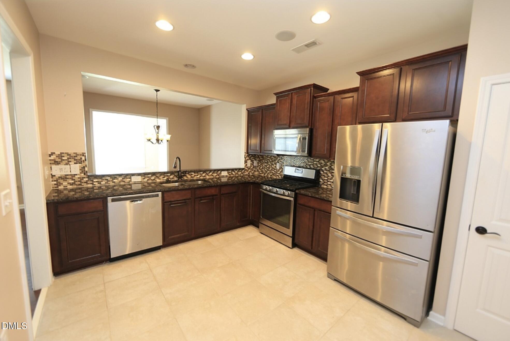 326 Brier Crossings Loop Durham, NC 27703 - Photo 4 of 12 a kitchen with granite countertop stainless steel appliances and refrigerator