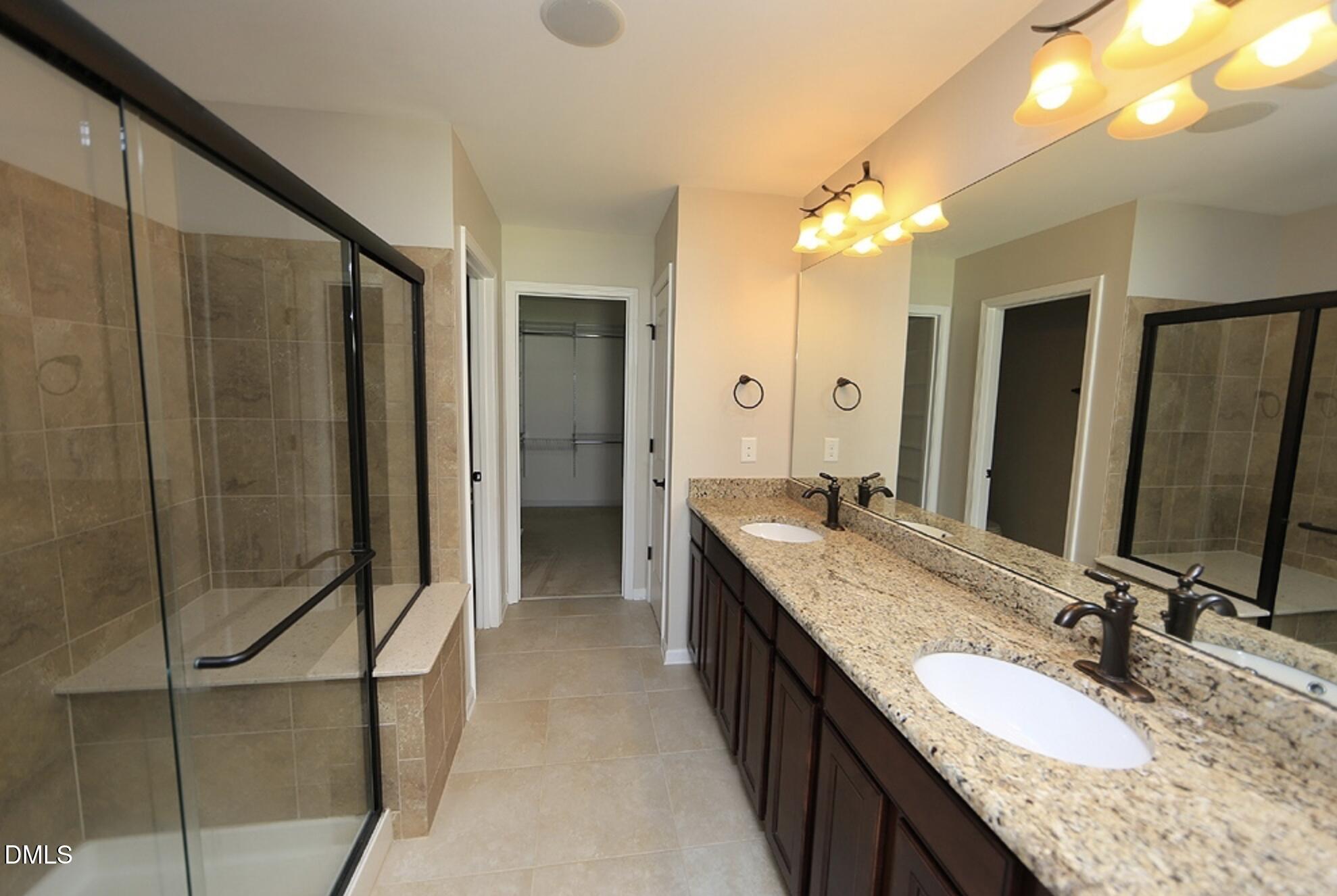 326 Brier Crossings Loop Durham, NC 27703 - Photo 8 of 12 a bathroom with a granite countertop sink a mirror and a shower