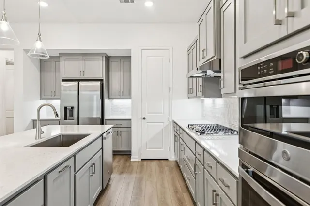 a kitchen with stainless steel appliances granite countertop a sink stove and cabinets