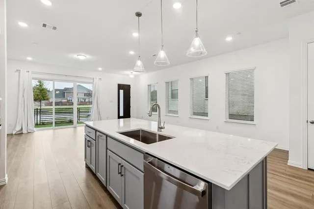a kitchen with stainless steel appliances granite countertop a sink a oven and wooden floors