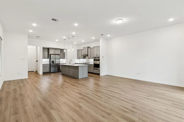 a view of kitchen view wooden floor stainless steel appliances and cabinets
