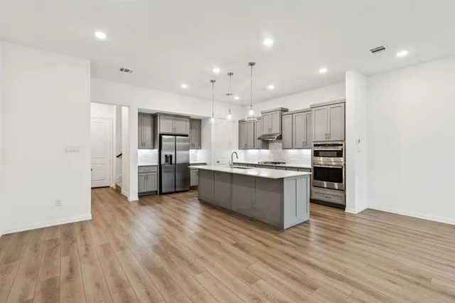 a large kitchen with stainless steel appliances granite countertop a large counter top and a stove top oven