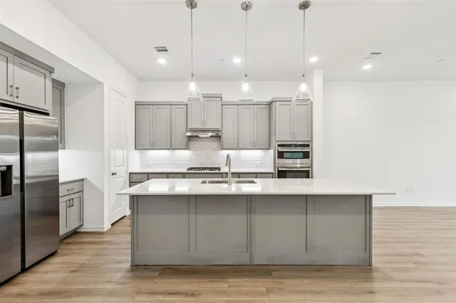 a kitchen with kitchen island a sink stainless steel appliances and cabinets