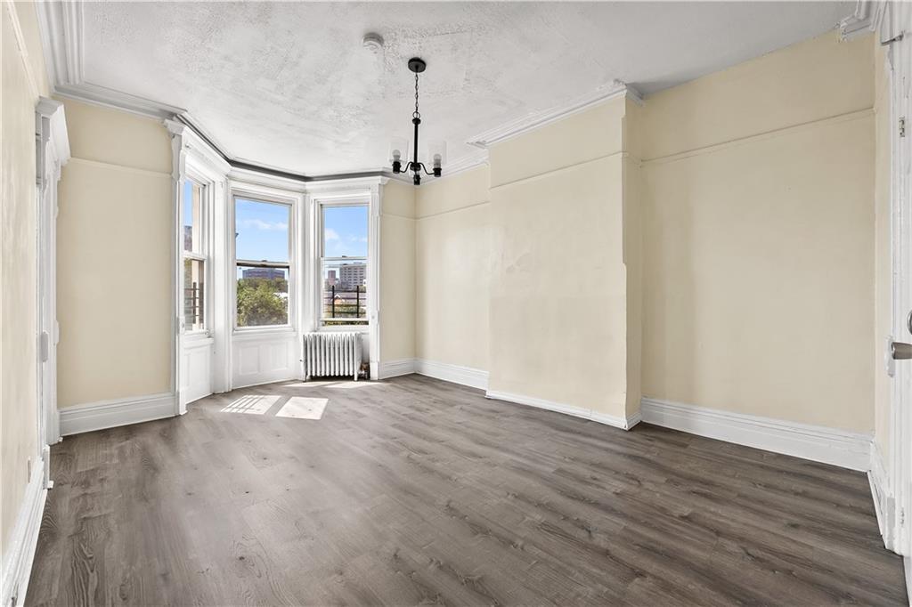 1271 Bushwick Avenue Brooklyn, NY 11207 - Photo 2 of 13 a view of an empty room with wooden floor and a window