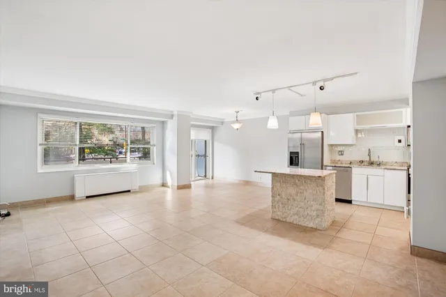 a view of a kitchen with refrigerator and white walls