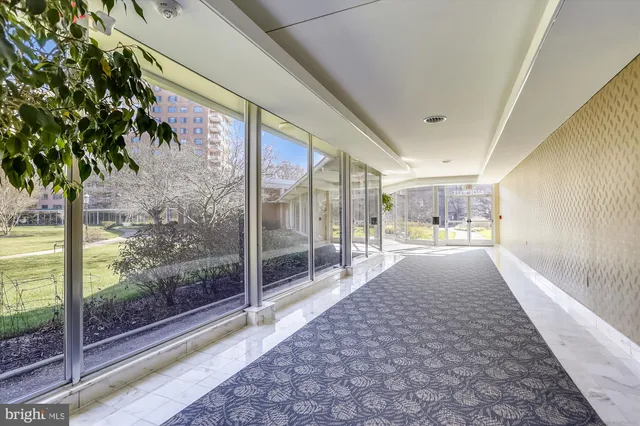 a view of a hallway with a chair and dining table