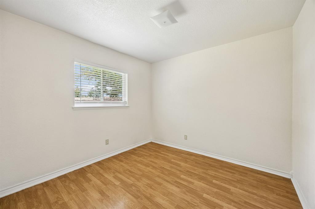 6221 Pine Street Rowlett, TX 75089 - Photo 11 of 12 Room featuring wood-finish flooring, white baseboards, and neutral wall paint