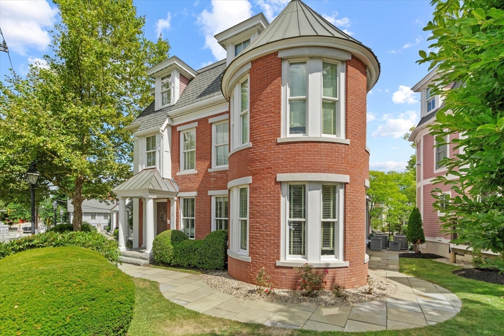 front view of a brick house with a yard