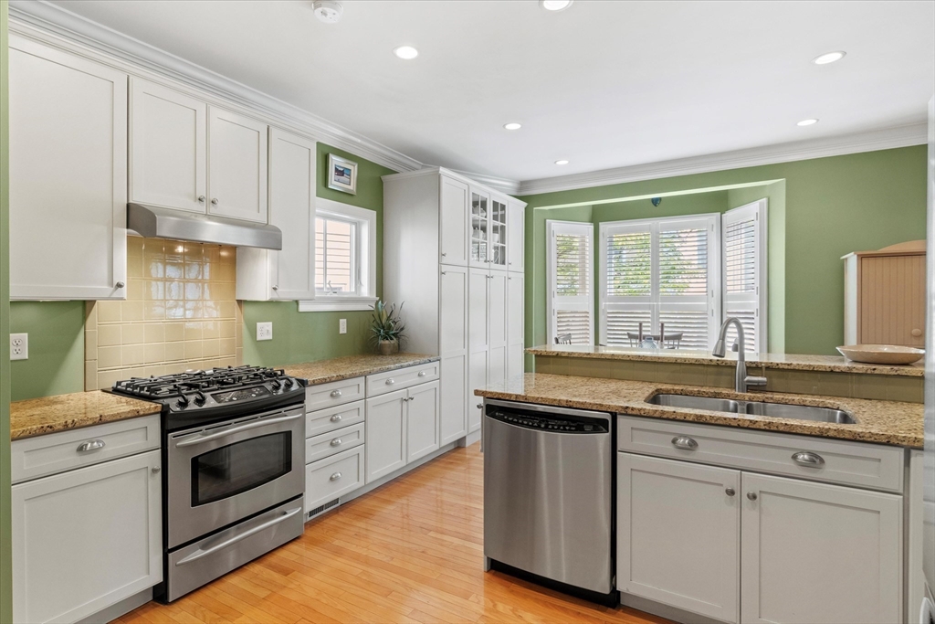 3 A Mill Street, Unit 3A Arlington, MA 02476 - Photo 5 of 38 a kitchen with granite countertop stainless steel appliances a stove sink and cabinets
