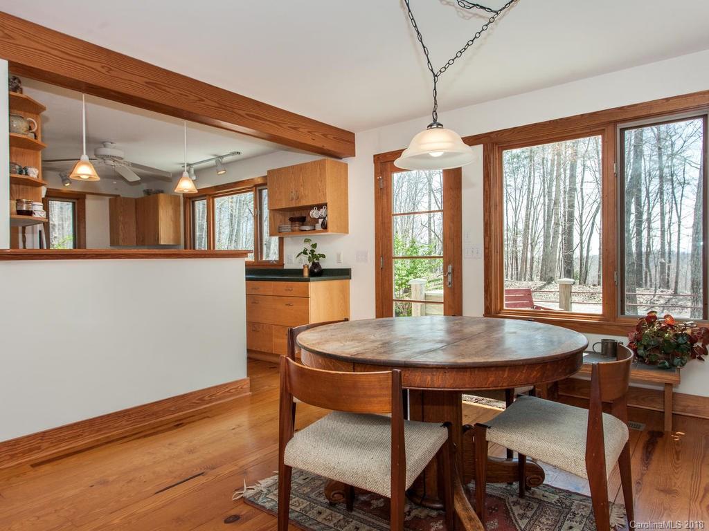2831 Polk County Line Road Rutherfordton, NC 28139 - Photo 11 of 30 a dining room with wooden floor a chandelier a wooden table and chairs
