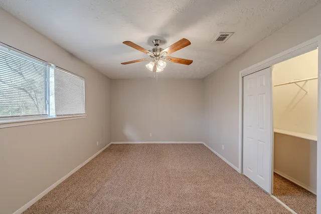 a spacious bathroom with a granite countertop sink a mirror and a bathtub