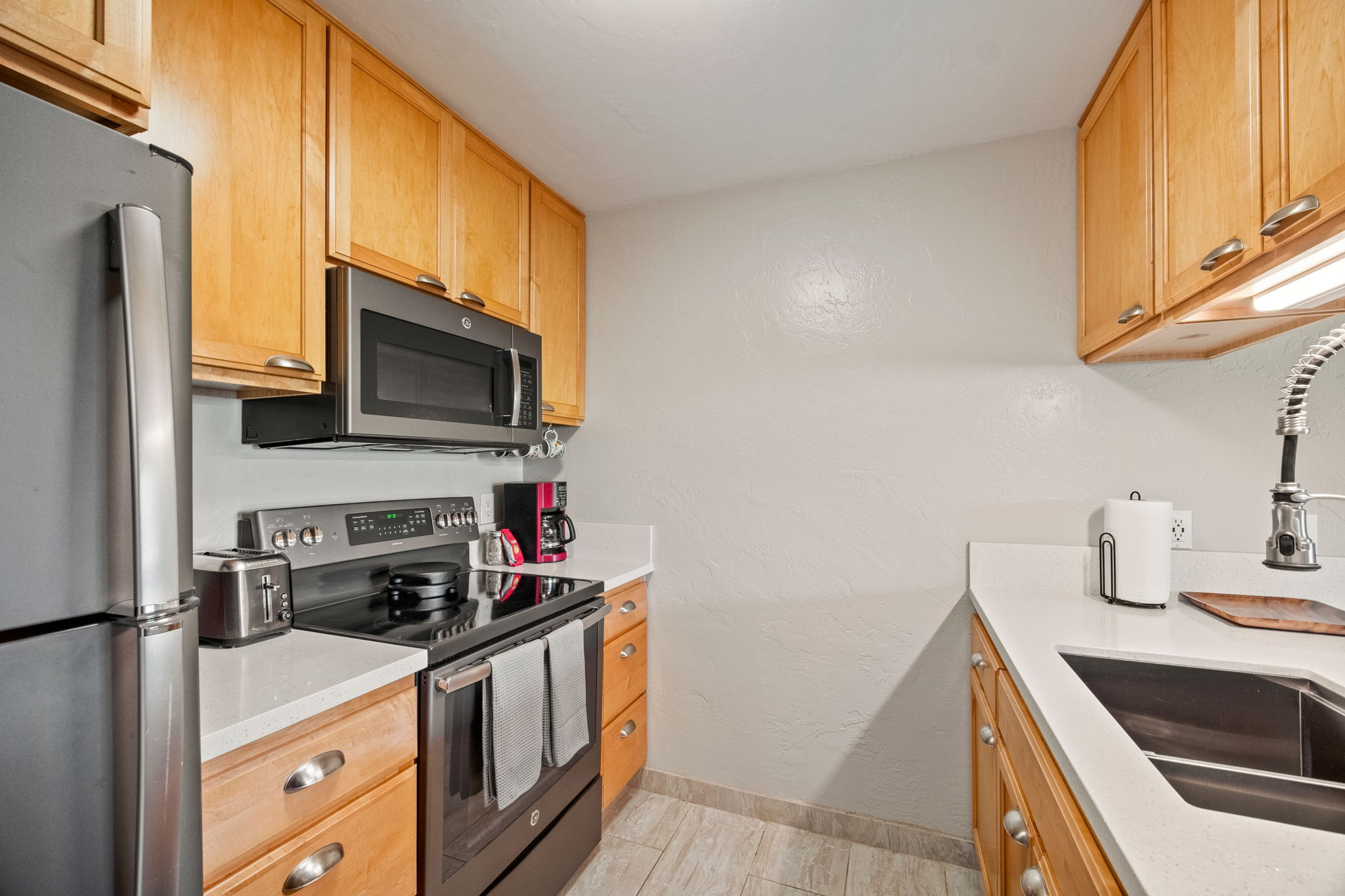 525 Aleka Loop, Unit H7 Kapaa, HI 96746 - Photo 10 of 30 a kitchen with stainless steel appliances a stove a sink and a microwave