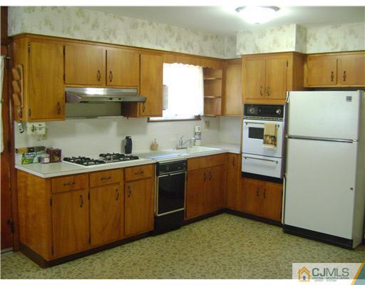 1437 Huron Road North Brunswick, NJ 08902 - Photo 3 of 11 a kitchen with cabinets a sink and white appliances