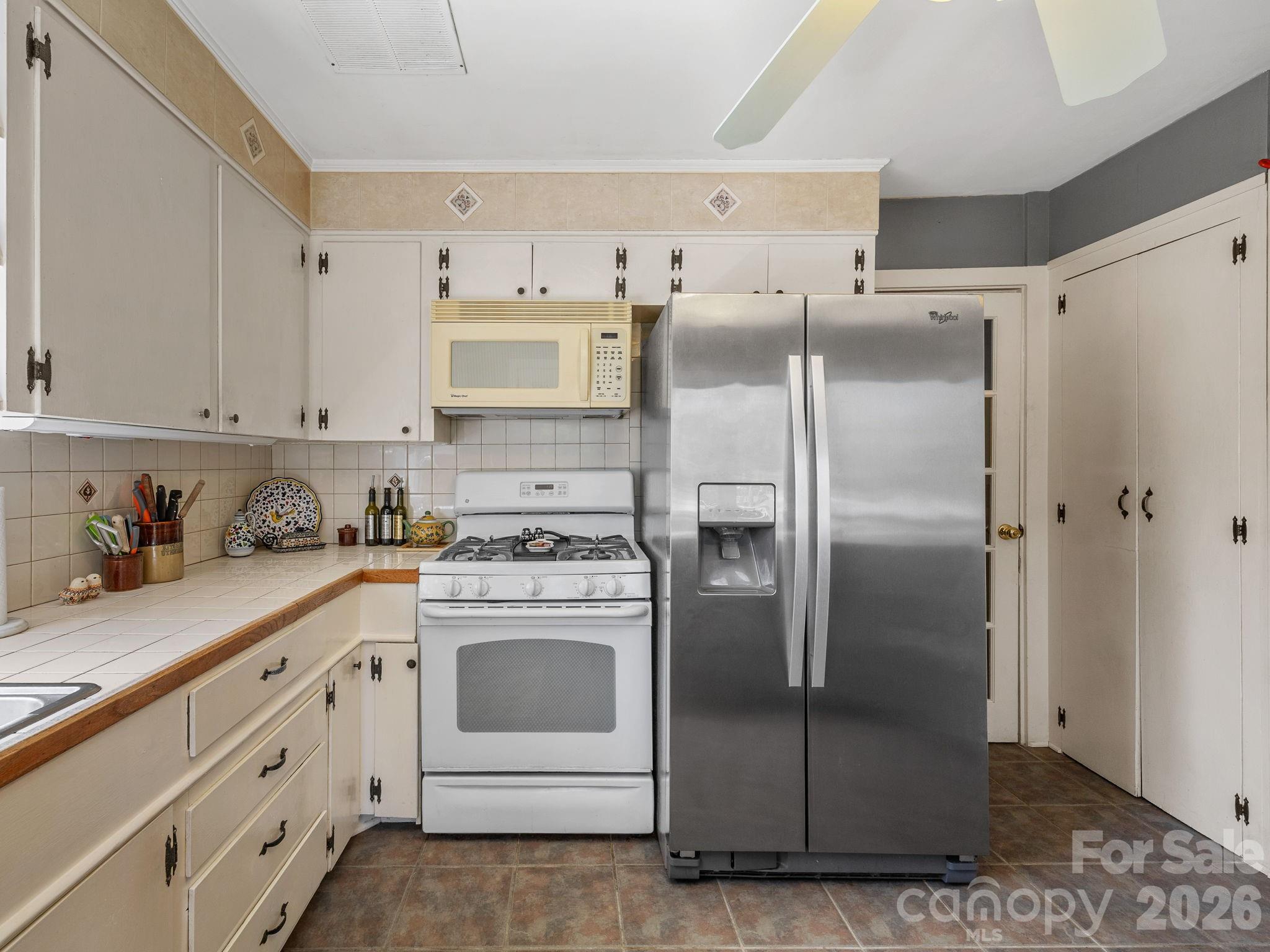 7 Rippy Road Tryon, NC 28782 - Photo 30 of 46 a kitchen with stainless steel appliances granite countertop a refrigerator a stove and white cabinets