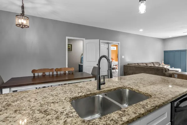 a kitchen with a granite countertop sink a stove and a refrigerator
