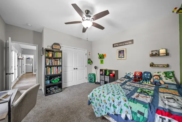 a bedroom with bed and a book shelf