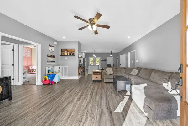 a living room with furniture and a wooden floor