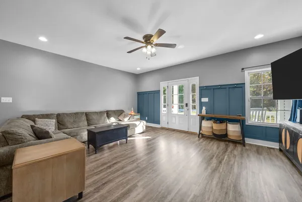 a living room with furniture and a wooden floor