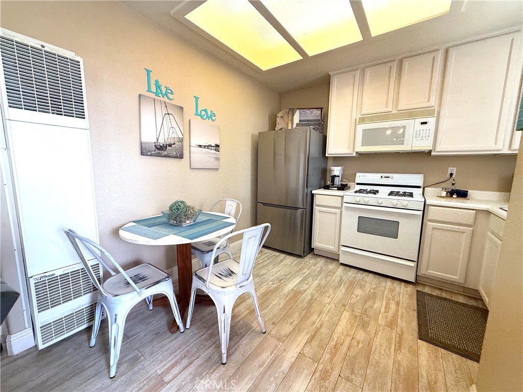 444 Pier Avenue, Unit 44 Oceano, CA 93445 - Photo 3 of 17 a kitchen with stainless steel appliances granite countertop a dining table chairs refrigerator and sink